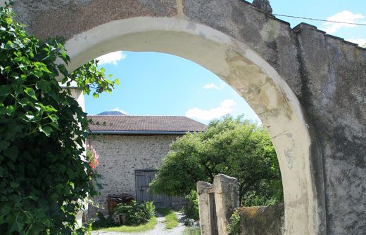 gemauerter Torbogen mit Blick in einen Innenhof